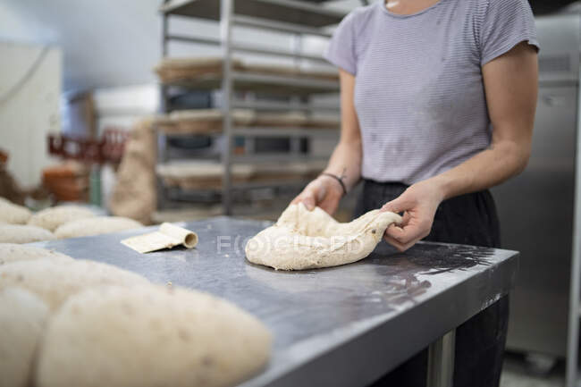 Nahaufnahme einer Frau, die in einer Bäckerei Brot zubereitet — Stockfoto