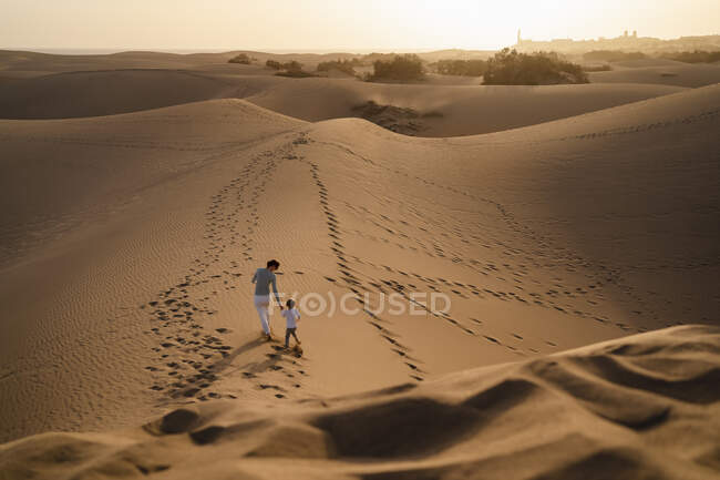 Mère et fille marchant main dans la main dans les dunes de sable, Gran Canaria, Espagne — Photo de stock