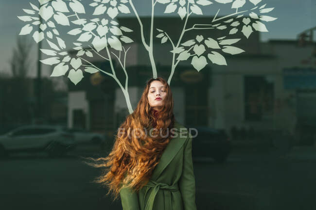 Portrait of redheaded young woman with closed eyes and blowing hair — Stock Photo