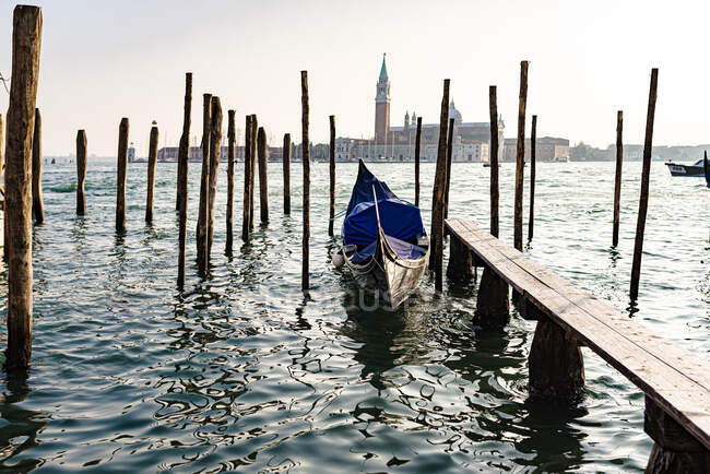 Italia, Venezia, Gondola ormeggiata ai poli costieri — Foto stock