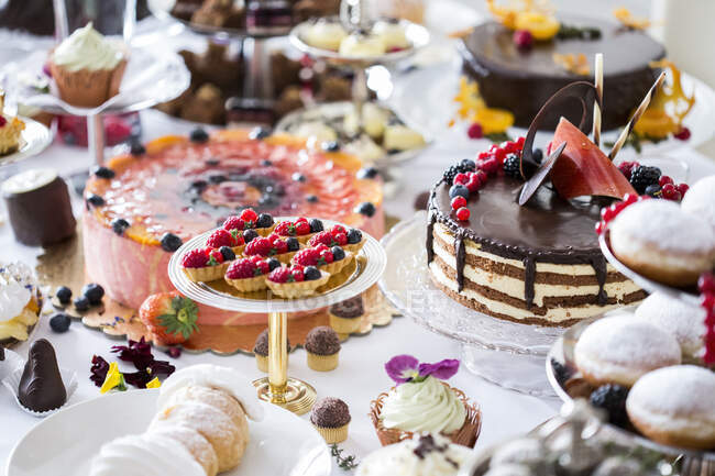 Tavolo da pranzo pieno di tutti i tipi di snack e dessert — Foto stock