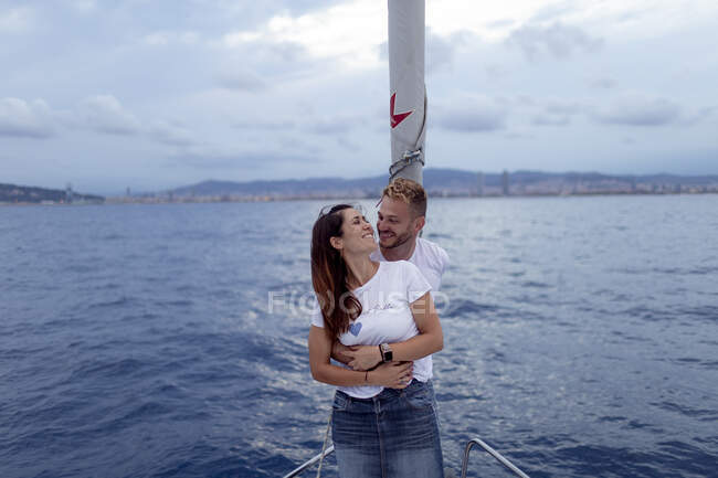 Couple souriant embrassant pendant le voyage à la voile — Photo de stock
