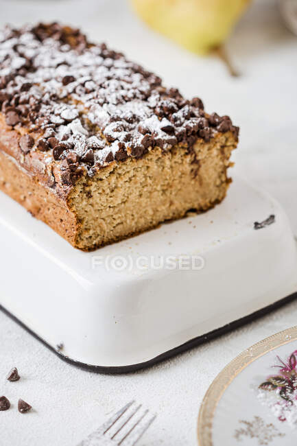 Loaf of oat bread with pears, powdered sugar and chocolate chips — Stock Photo