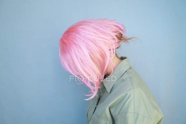 Jeune femme portant une perruque rose et regardant vers le bas — Photo de stock