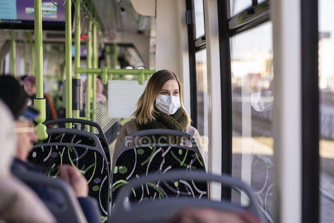 Femme avec masque facial assis dans le tramway — Photo de stock
