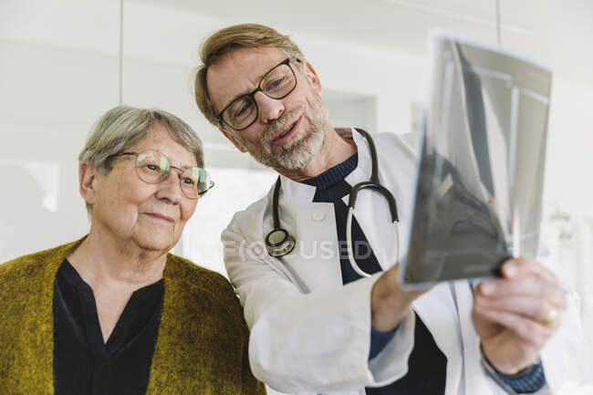Médecin discutant d'une image radiographique avec un patient âgé — Photo de stock