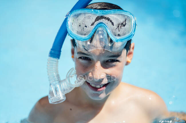 Retrato de niño sonriente con gafas de buceo en la piscina - foto de stock