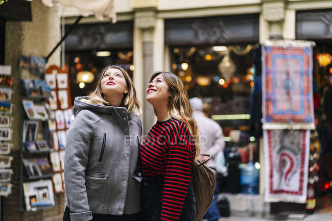 Duas jovens mulheres na cidade olhando para cima — Fotografia de Stock