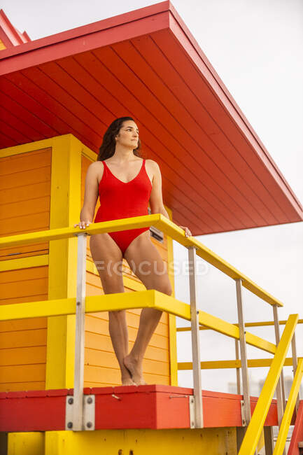 Портрет женщины в красном купальнике в хижине спасателя на Майами-Бич, Майами, Флорида, США — стоковое фото