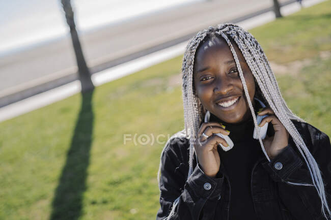 Портрет улыбающейся девочки-подростка с косичками на улице — стоковое фото