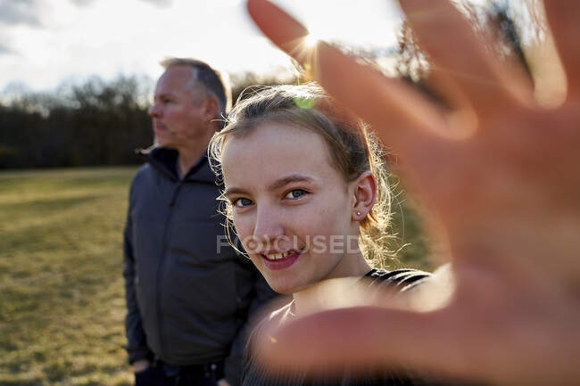 Portrait de fille souriante avec son père sur une prairie — Photo de stock