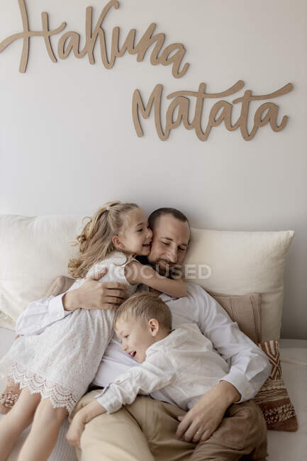 Сімейний портрет щасливого батька і двох його дітей, які обіймаються вдома. — стокове фото