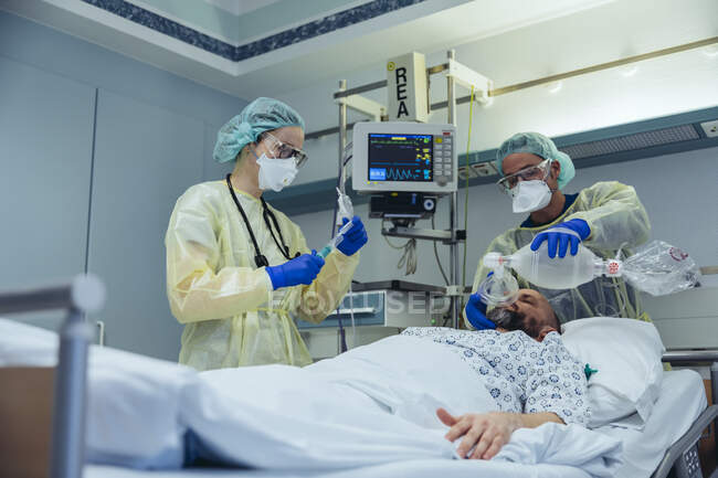 Врачи с мешком маски клапана ухода за пациентом в отделении неотложной помощи больницы — стоковое фото