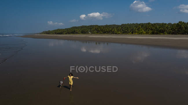Jovem despreocupada levando seu cão para um passeio na praia, Costa Rica — Fotografia de Stock