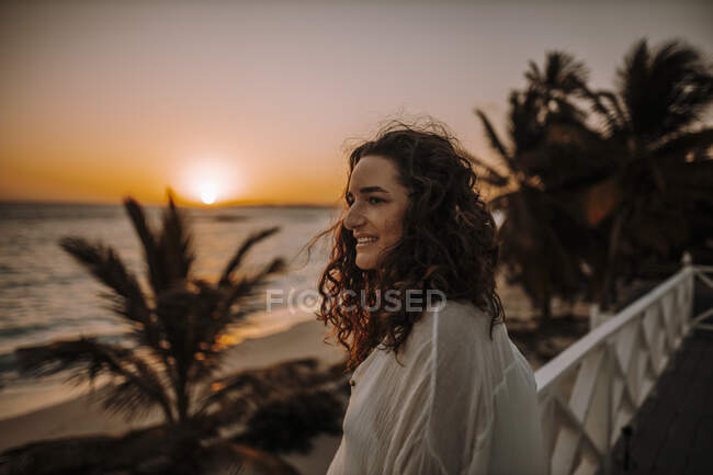 Женщина наслаждается восходом солнца на море — стоковое фото