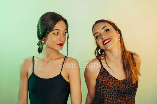 Porträt zweier junger Frauen vor grünem Hintergrund — Stockfoto
