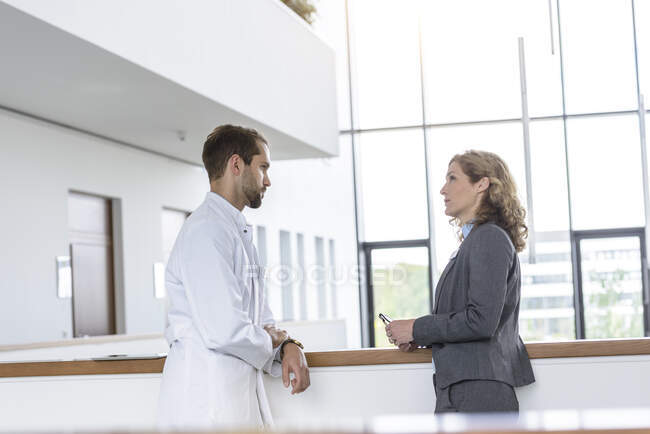 Femme d'affaires et médecin parlant à l'hôpital — Photo de stock