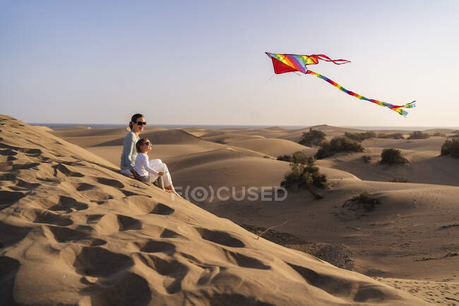Мать и дочь запускают воздушного змея в песчаных дюнах, Гран-Канария, Испания — стоковое фото