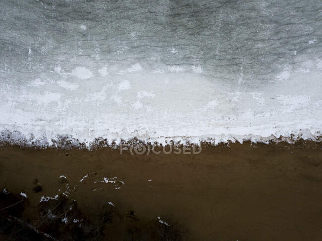 Una superficie de río con hielo y arena en el lago. - foto de stock