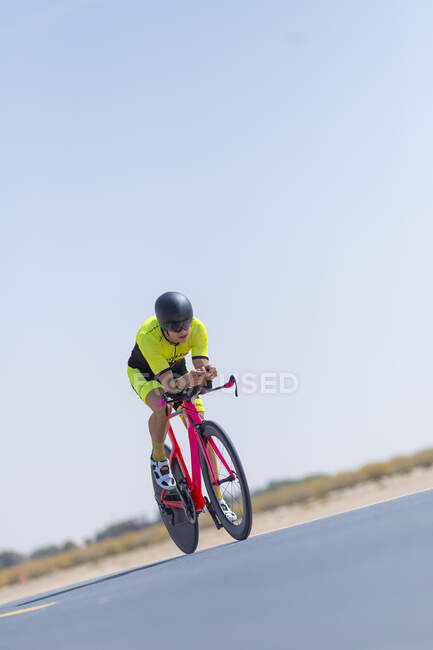 Ciclista determinato in bicicletta su strada contro il cielo azzurro, Dubai, Emirati Arabi Uniti — Foto stock