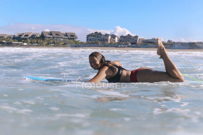 Female surfer lying on surf board, Bali, Indonesia — Stock Photo