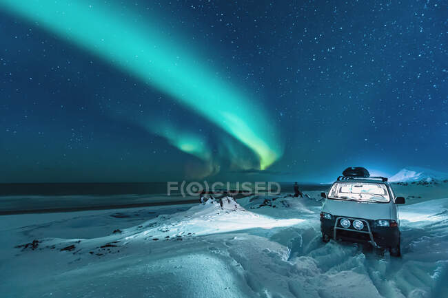 Северное сияние над пляжем с фургоном для кемперов, Берлеваг, Норвегия — стоковое фото