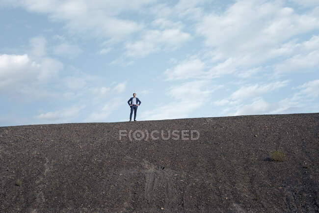 Maduro hombre de negocios de pie en una punta de mina en desuso - foto de stock