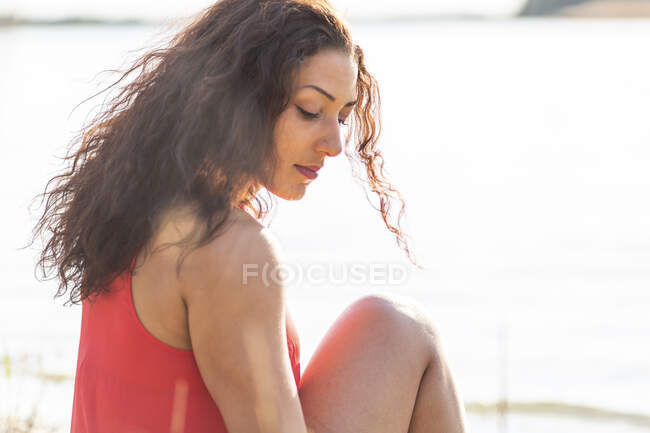 Портрет молодой женщины, сидящей на берегу озера — стоковое фото
