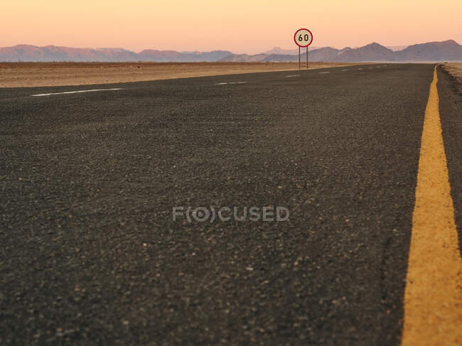 Leere Asphaltstraße in der Wüste bei Sonnenuntergang, Namibia — Stockfoto