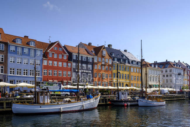 Dänemark, Kopenhagen, Boote vor Anker am Nyhavn Kanal mit bunten Reihenhäusern im Hintergrund — Stockfoto