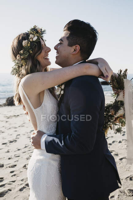 Felice coppia di sposi in spiaggia — Foto stock