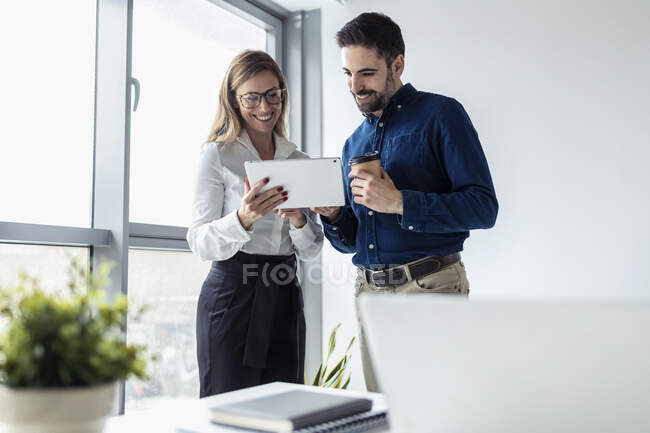 Imprenditore e donna che lavorano insieme in ufficio, utilizzando tablet digitale — Foto stock