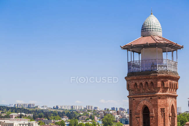 Minarete de la Mezquita de Jumah contra el cielo azul claro durante el día soleado, Tiflis, Georgia - foto de stock