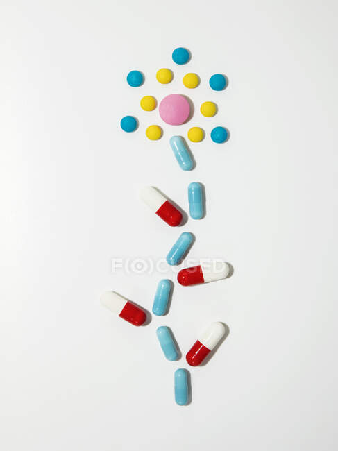 Pills and capsules arranged in shape of blooming flower — Stock Photo