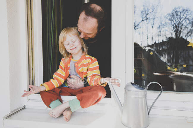 Pai olhando para a filha sentada no peitoril da janela — Fotografia de Stock