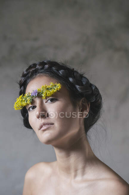 Hermosa joven con flor pegada en la frente - foto de stock
