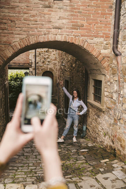 Donna che fotografa la sua amica nel pittoresco centro storico, Greve in Chianti, Toscana, Italia — Foto stock