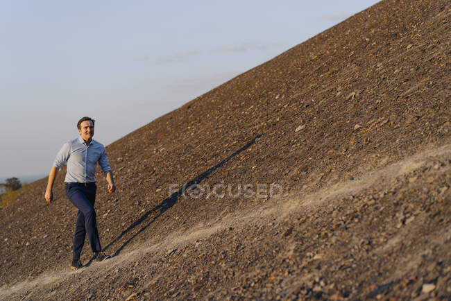 Homme d'affaires mature marchant sur une pointe de mine désaffectée — Photo de stock