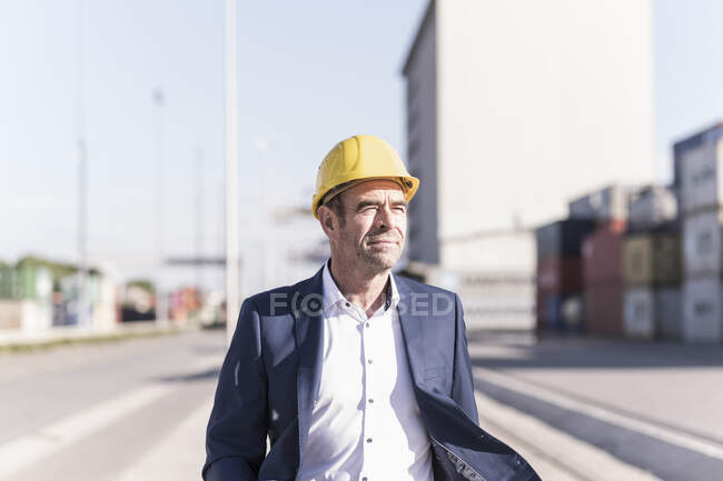 Porträt eines Geschäftsmannes mit Schutzhelm am Industriestandort — Stockfoto