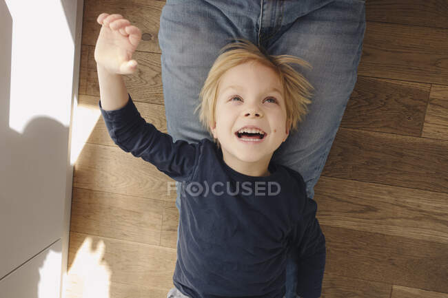 Retrato de un niño feliz jugando con su padre en casa - foto de stock