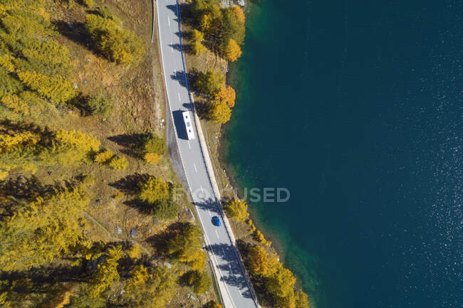 Suiza, Cantón de los Grisones, Saint Moritz, Drone vista de la carretera que se extiende a lo largo de la orilla del lago Sils en otoño - foto de stock