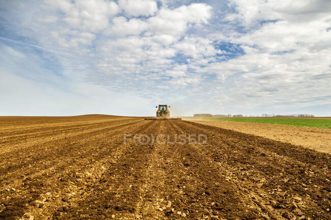 Весной фермер на тракторном пашне — стоковое фото