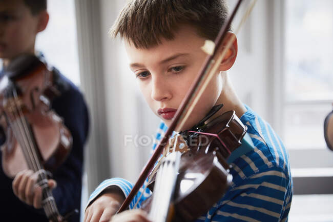 Menino tocando violino durante uma aula — Fotografia de Stock