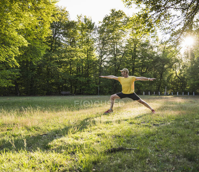 Reifer Mann praktiziert Yoga auf Gras gegen Bäume im Park — Stockfoto
