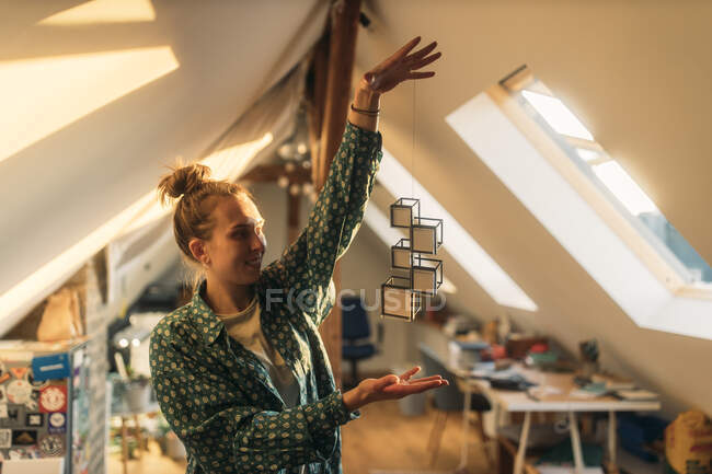 Junge Frau hält Design an Schnur zu Hause — Stockfoto