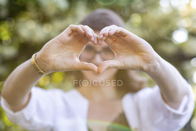 Giovane donna che forma un cuore con le mani — Foto stock