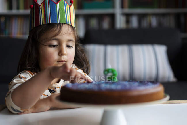 Портрет маленькой девочки, трогающей торт — стоковое фото