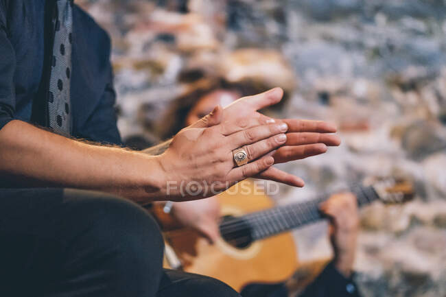 Close-up of singer clapping hands while man playing guitar in club — Stock Photo