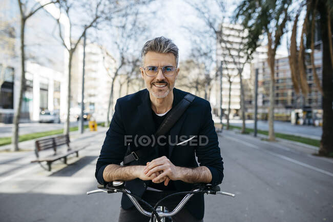 Ritratto di un uomo d'affari dai capelli grigi con bicicletta in città — Foto stock