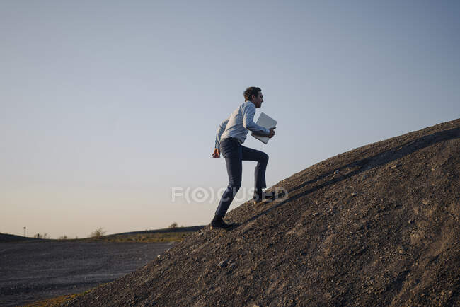 Reifer Geschäftsmann mit Laptop auf stillgelegter Minenspitze — Stockfoto